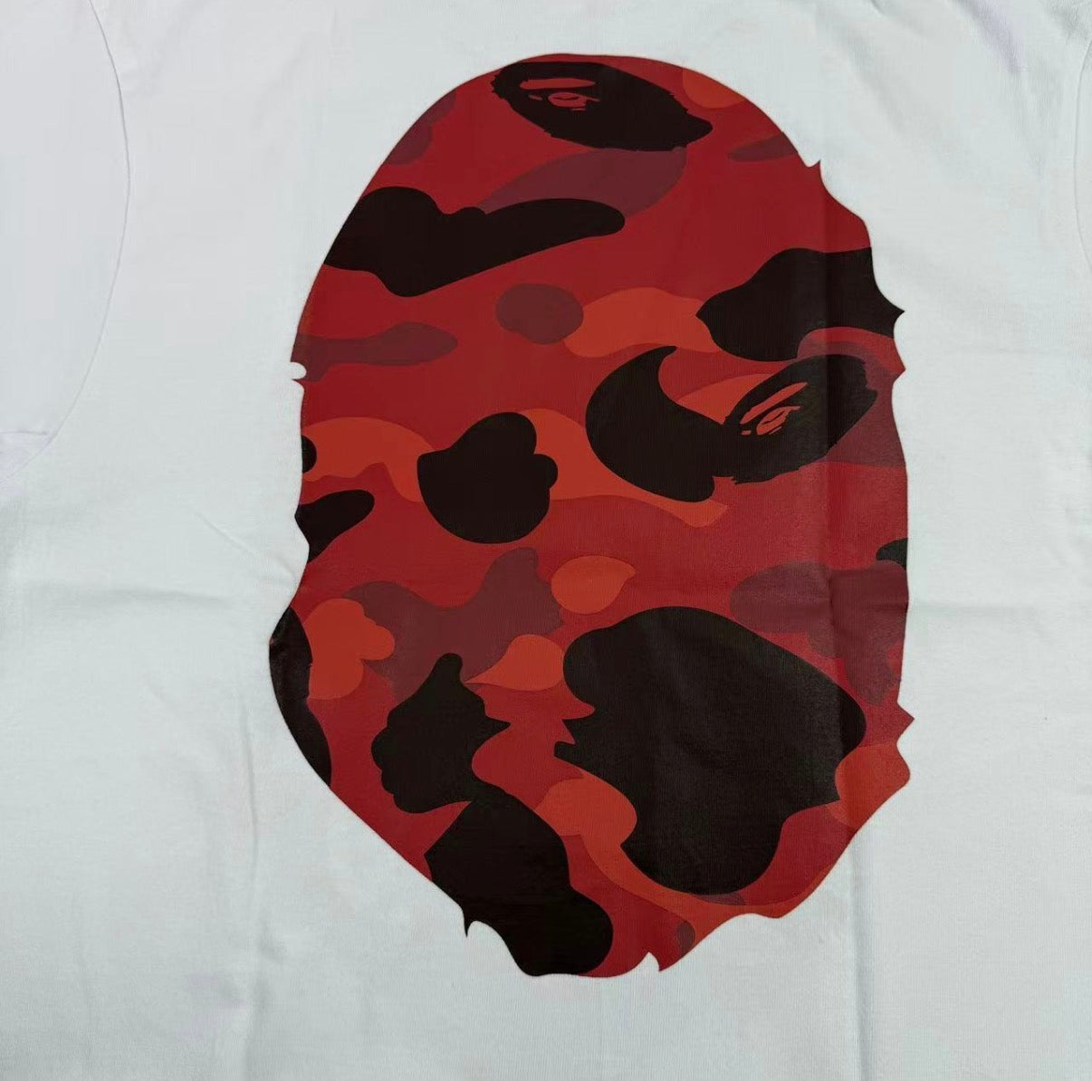 White t-shirt with red and black camouflage logo on a white background