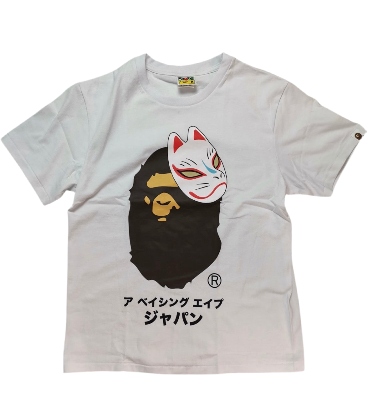 White t-shirt with a graphic design of a face wearing a mask and Japanese text on a white background