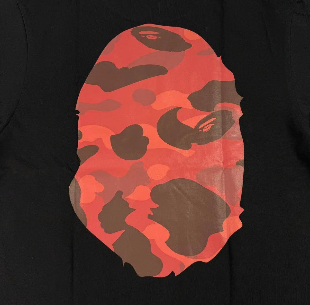 Black hoodie with a red and brown camouflage logo on a black background